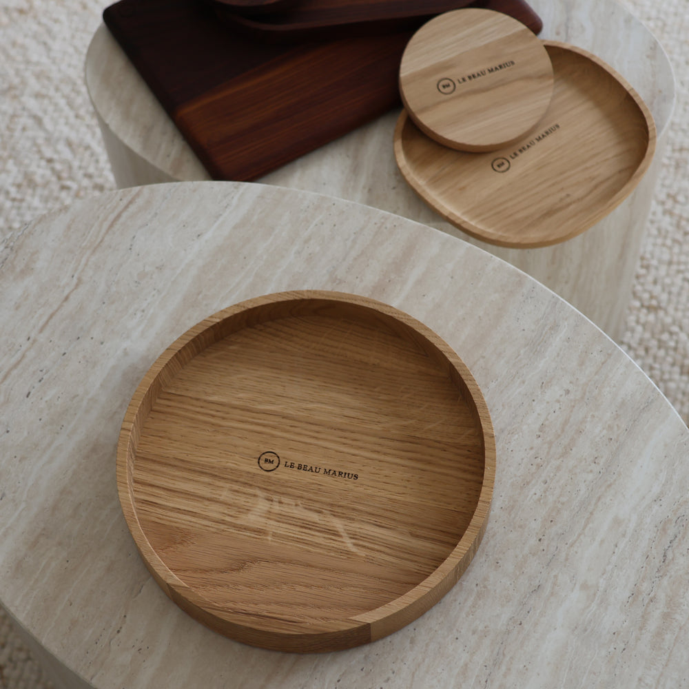 Coupe à fruits en chêne massif Ø 20 cm gravée Le Beau Marius sur une table basse en travertin