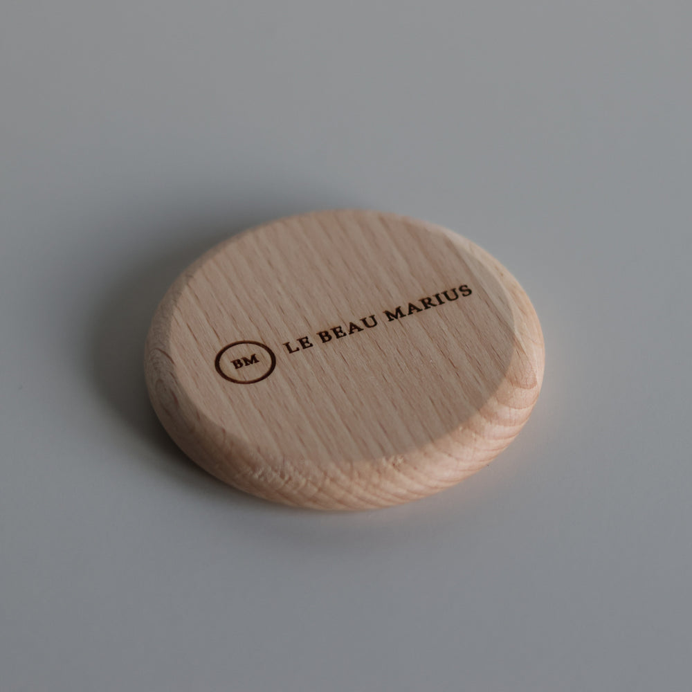 Décapsuleur aimanté en hêtre Ø 65 mm gravé du logo Le Beau Marius, vue de trois quarts