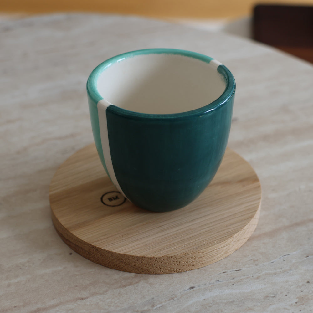 Tasse en céramique verte posée sur un dessous de mug en chêne massif Le Beau Marius