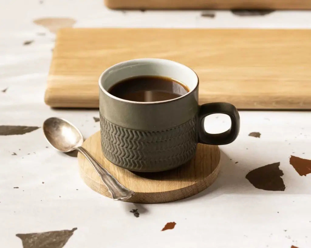 Dessous de mug en chêne massif Le Beau Marius sous une tasse de café