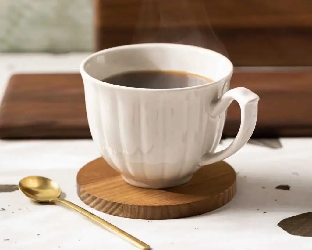Dessous de mug en frêne thermotraité Le Beau Marius sous une tasse de café