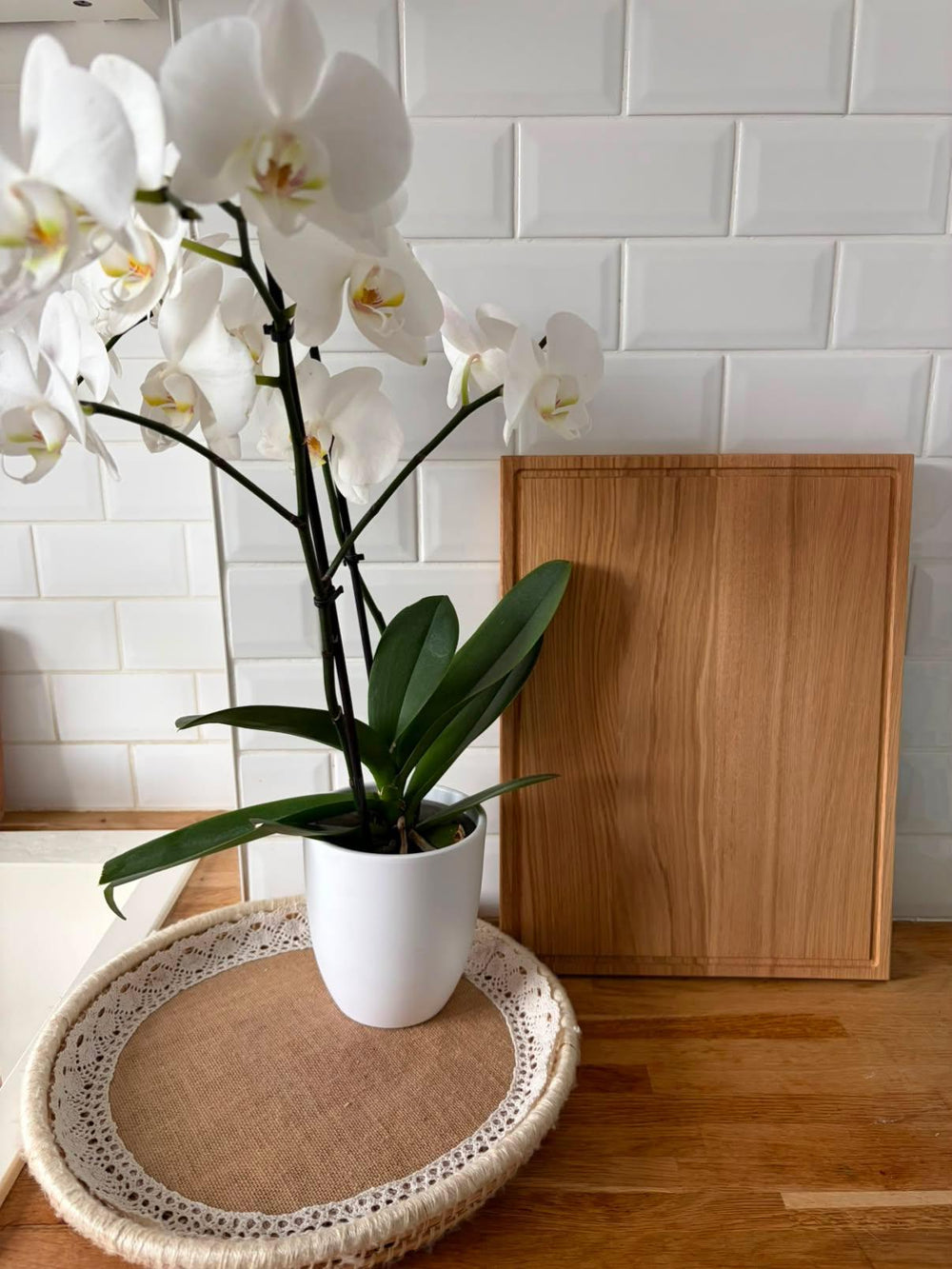 Planche à découper en chêne massif Le Beau Marius posée dans une cuisine près d'une orchidée