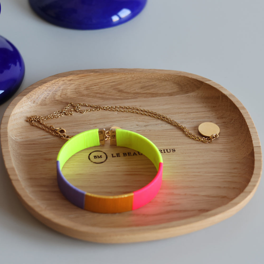 Bracelet coloré et collier doré dans le vide-poche galet en chêne massif Le Beau Marius